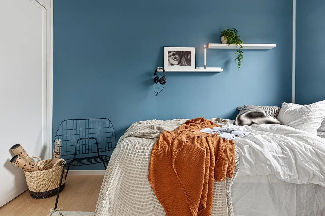 White duvet and pillows with an orange throw