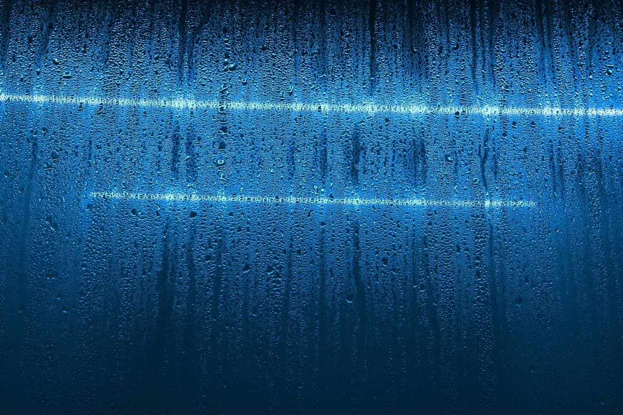 Moisture droplets on blue-tinted window glass