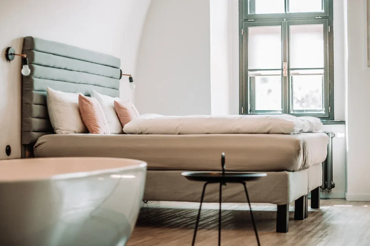 Daybed with cushions beside bright windows