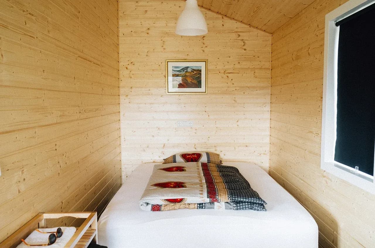 Single bed in a wood-panelled room