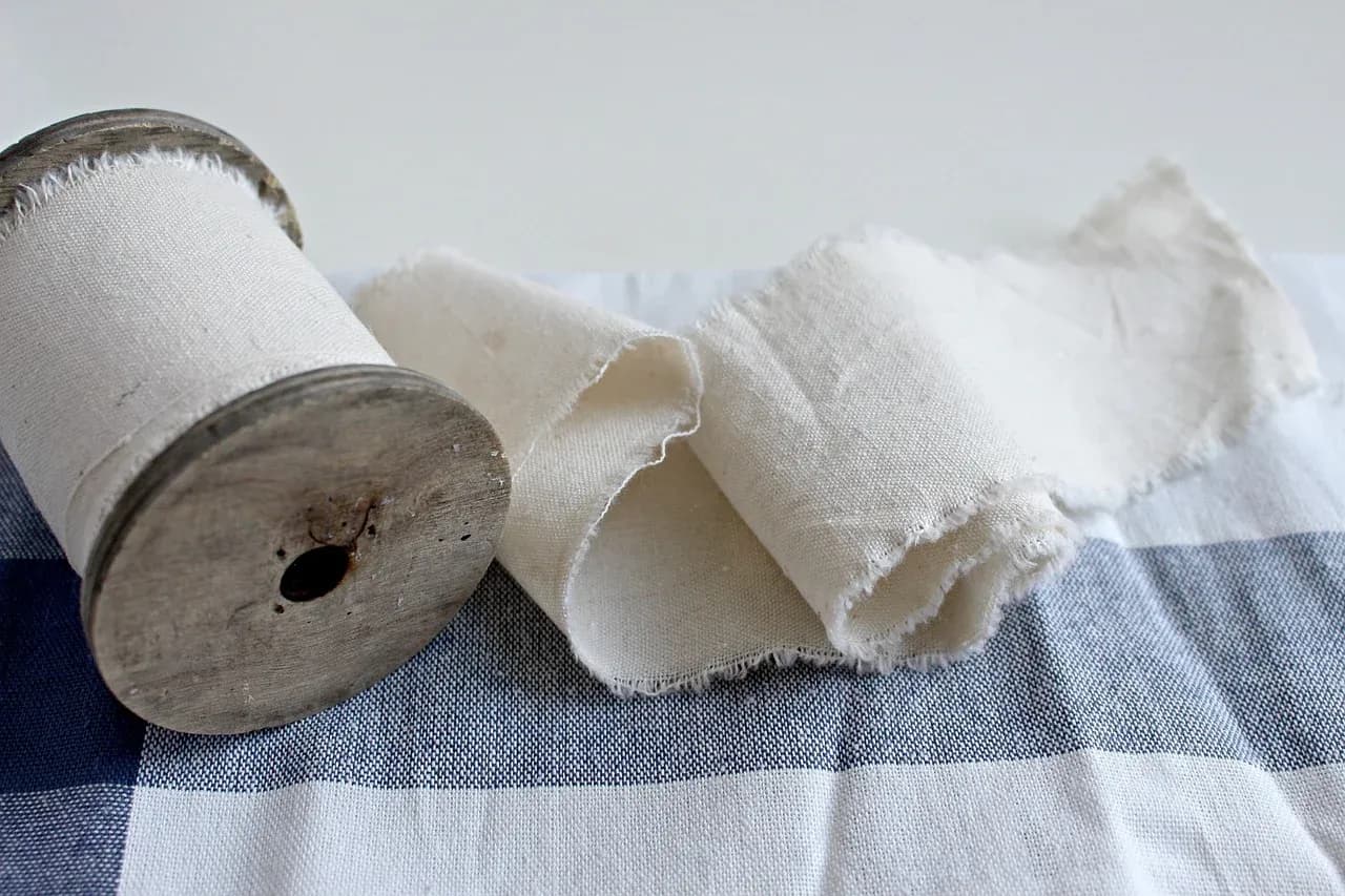 Roll of cream fabric and folded textile pieces