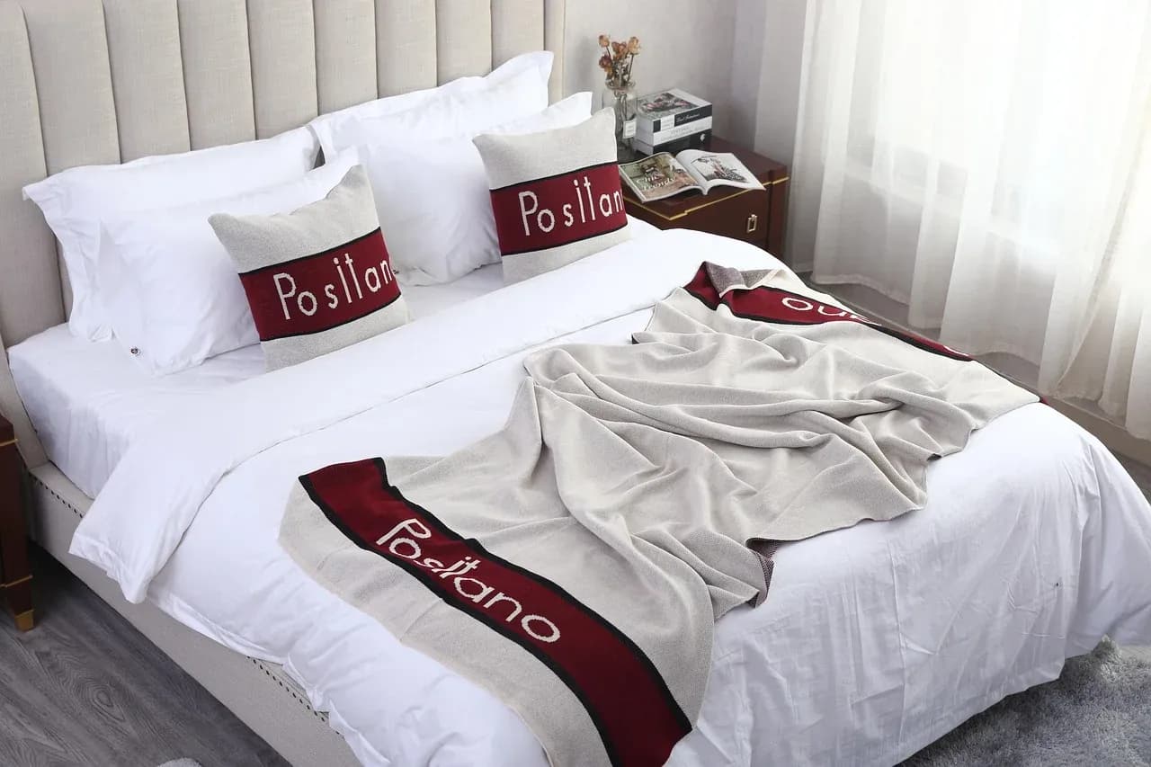 White bed with pillows and burgundy accent cushions