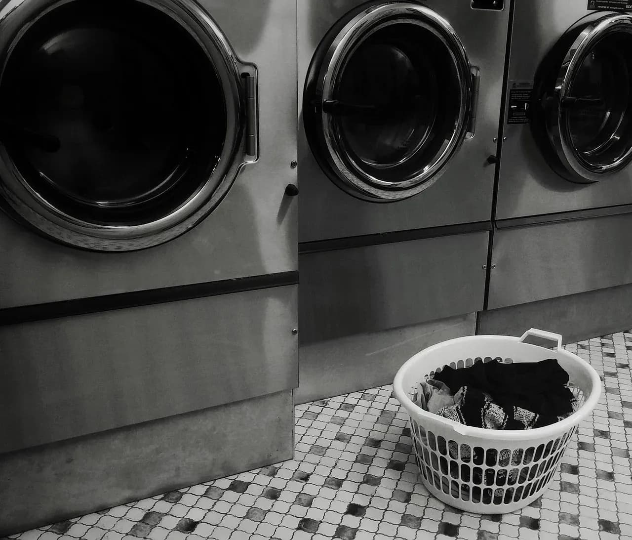 Laundry basket beside front-loading washing machines