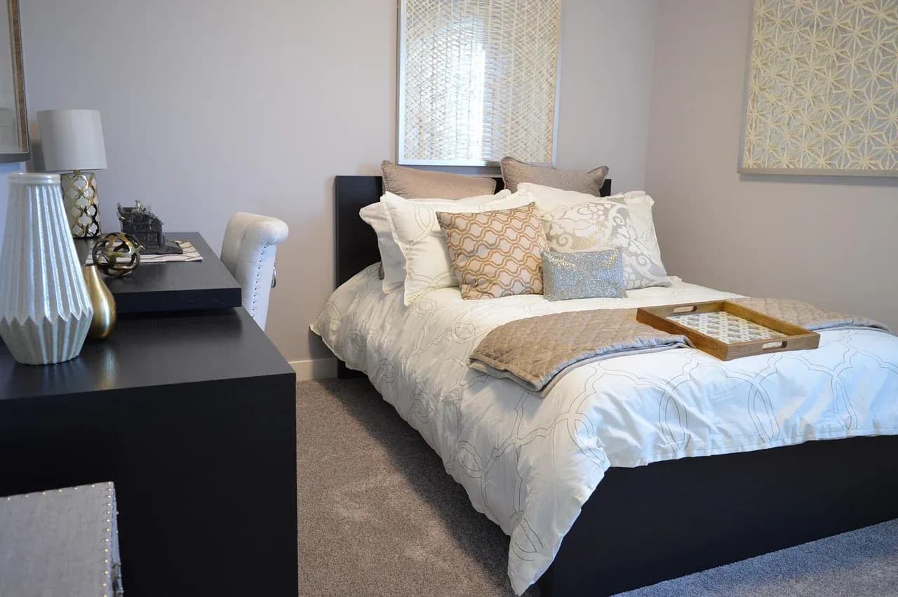 Made bed with a folded throw in a compact bedroom