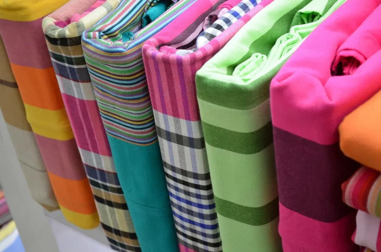 Folded colourful bed linen arranged upright