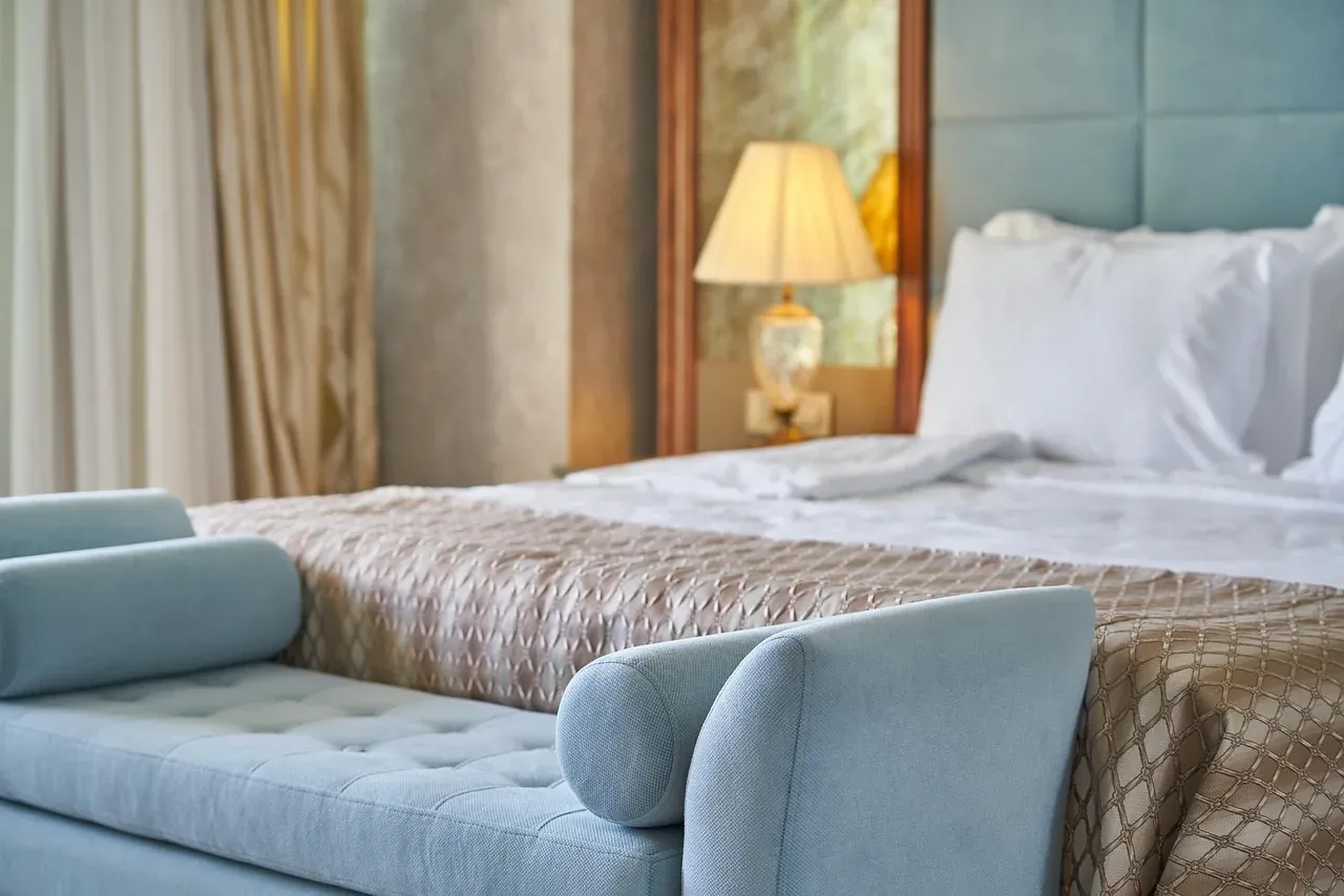 Bed with white pillows and a blue padded headboard