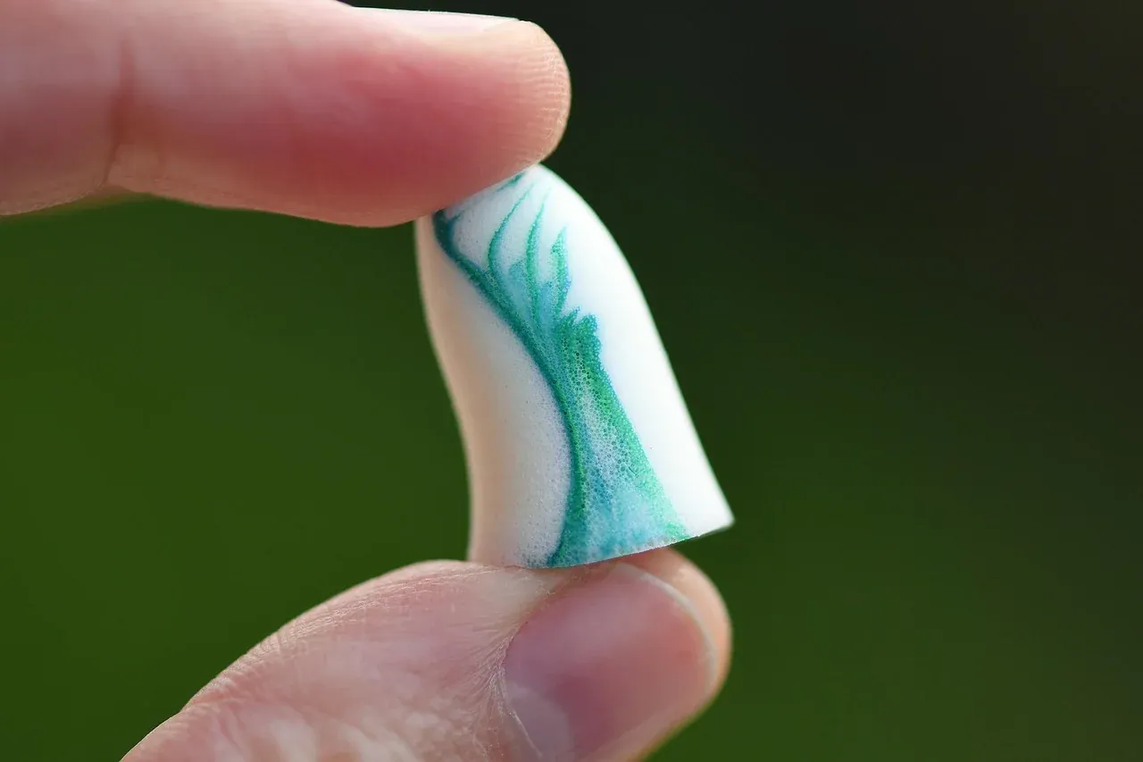 Single foam earplug held between two fingers