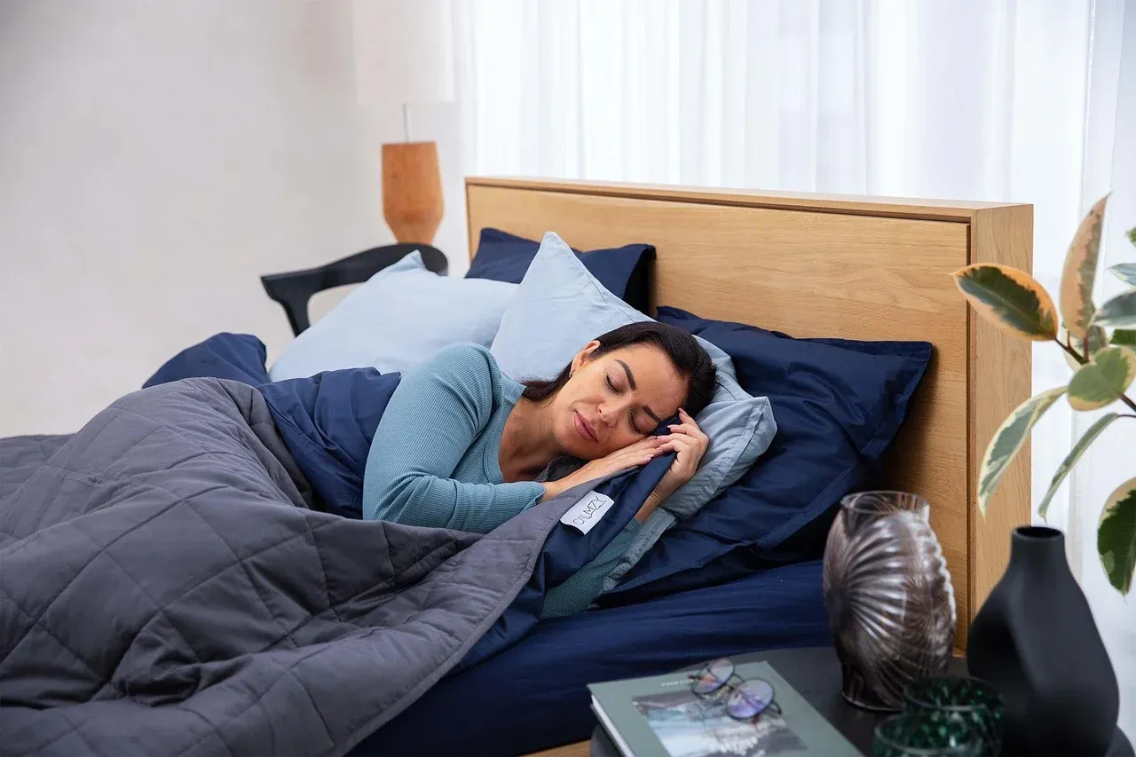 Woman resting under a blue duvet