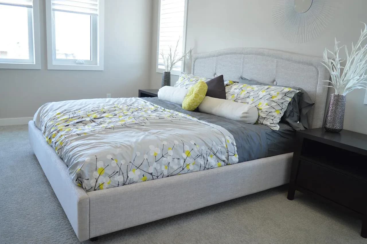 Bed with a patterned cover beside a window