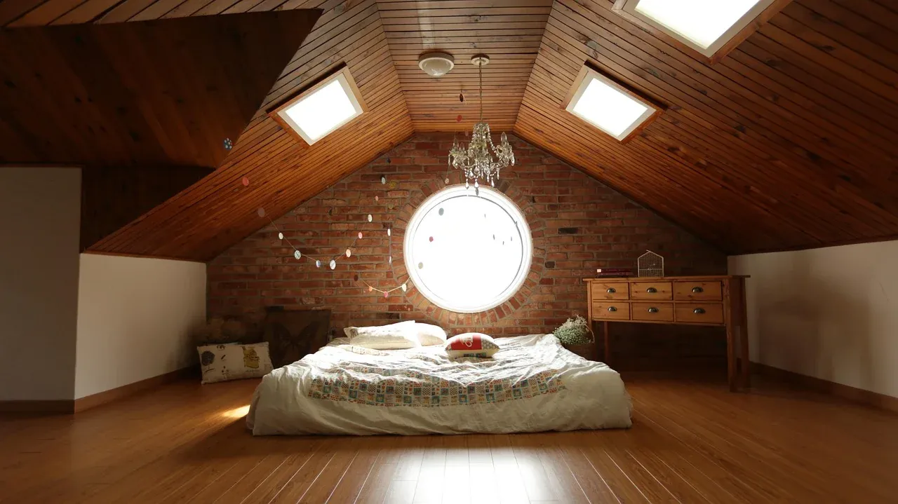 Low bed beneath a round attic window