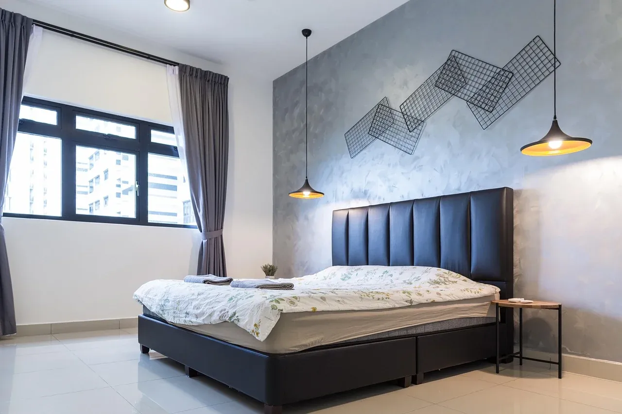 Bed with white linen and a dark padded headboard