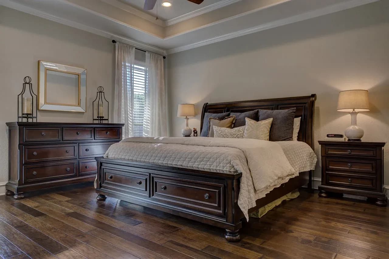 Bed with a dark wooden frame and layered bedding