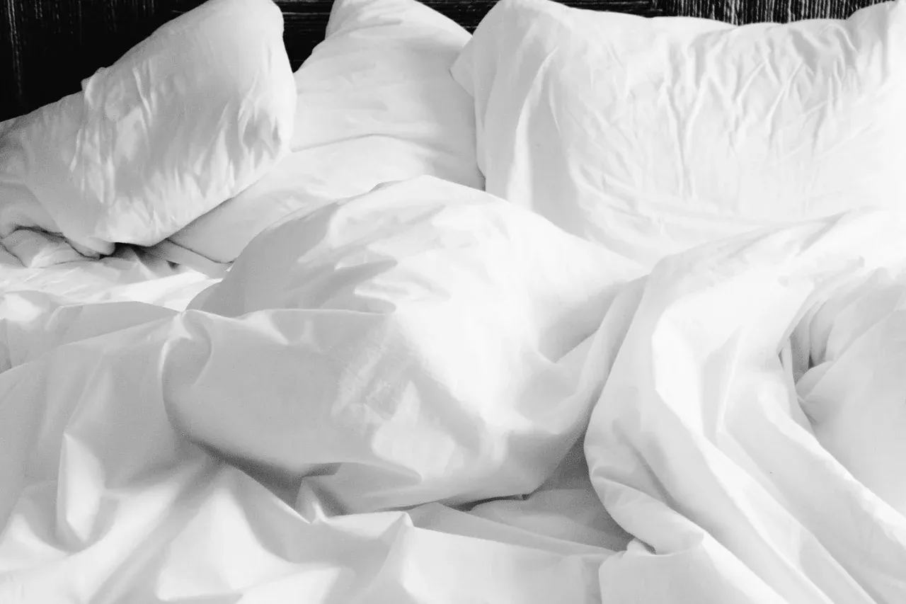 Rumpled white pillows and sheets