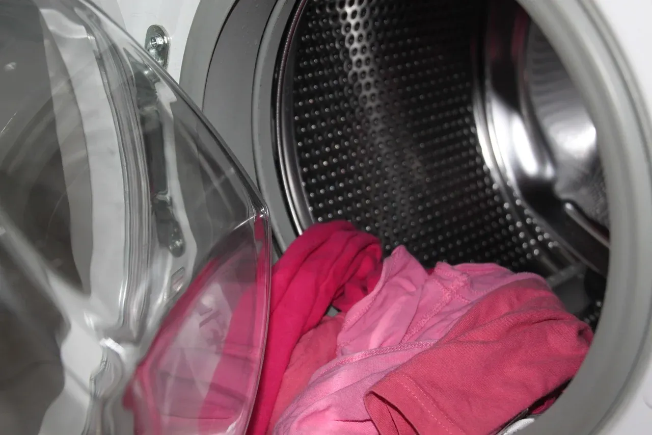 Pink laundry inside a washing-machine drum