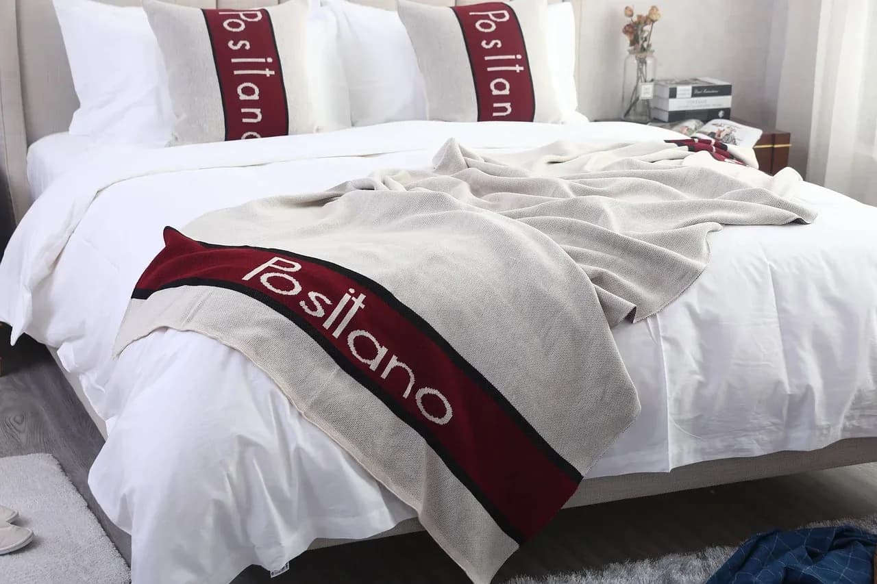 White bed linen with burgundy accent cushions