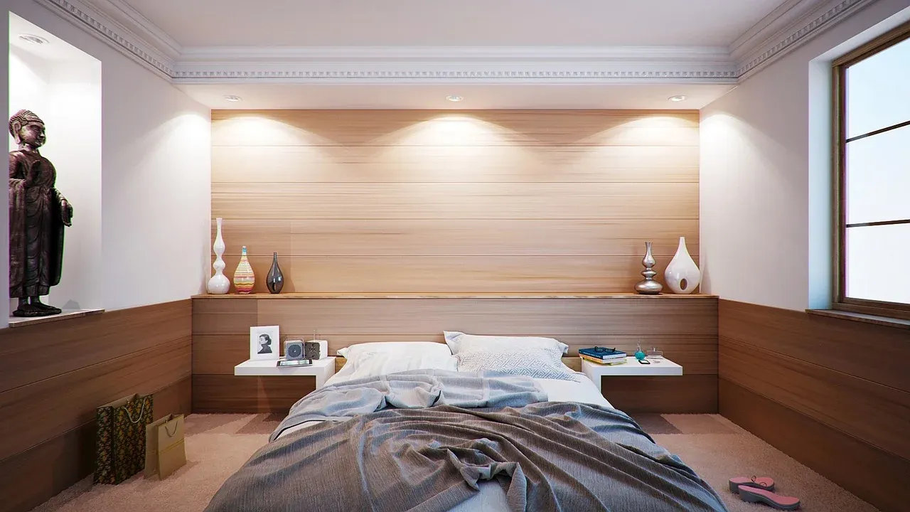 Double bed with white pillows and a wooden headboard