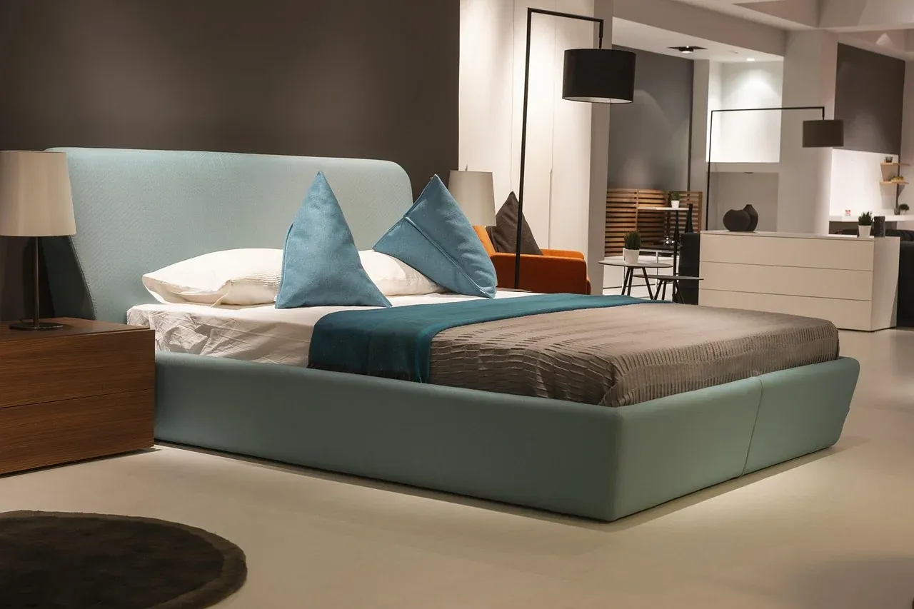 Low upholstered bed with layered pillows